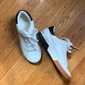 Size 7, white sneakers with black accent trim.